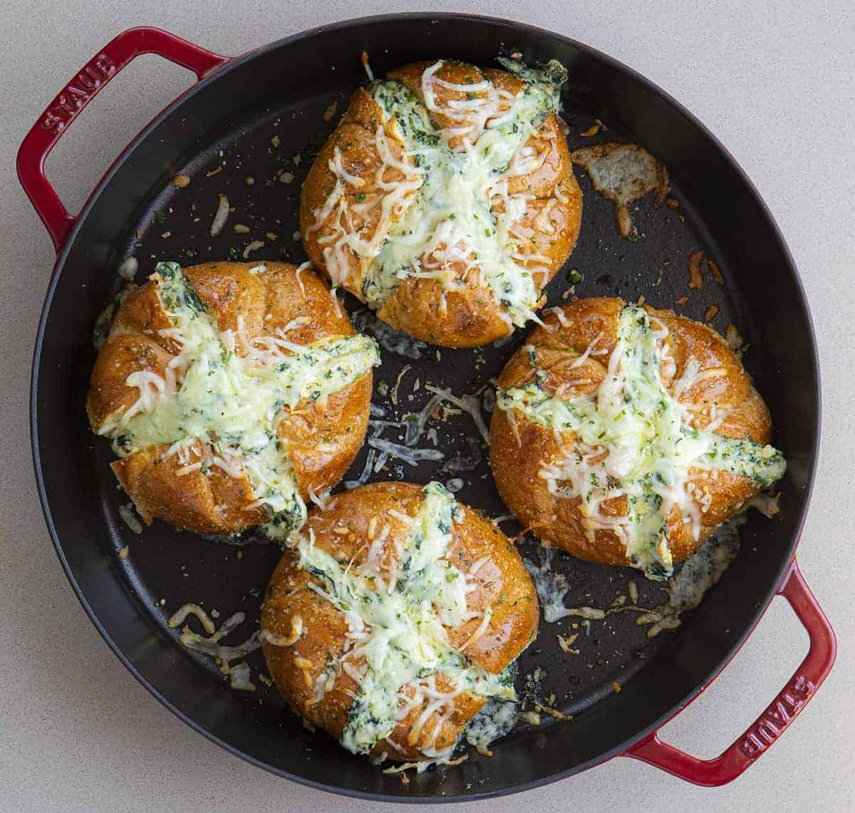 Take your appetizer to the next level with this Spinach Artichoke Dip Pull-Apart Bread! Spinach Artichoke Bread, Garlic Spinach Bread, Pull Apart Bread, Appetizer, How to Make Individual Spinach Artichoke Breads, Cheesy Pull Apart Bread, recipes, i am baker, iambaker Overhead view of Spinach Artichoke Pull Apart Bread in Red Skillet