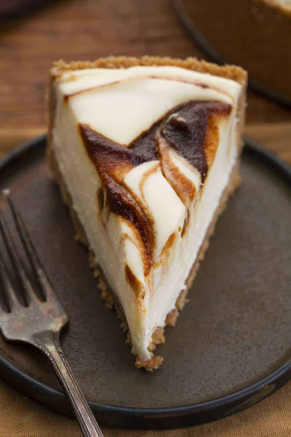 Apple Butter Cheesecake is a no-bake cheesecake made with a graham cracker crust filled with a creamy cheesecake and apple butter swirl. Cheesecake, Apple Butter Cheesecake, No Bake Cheesecake, Classic Cheesecake, Dessert, recipes, i am baker, iambaker Slice of Apple Butter Cheesecake