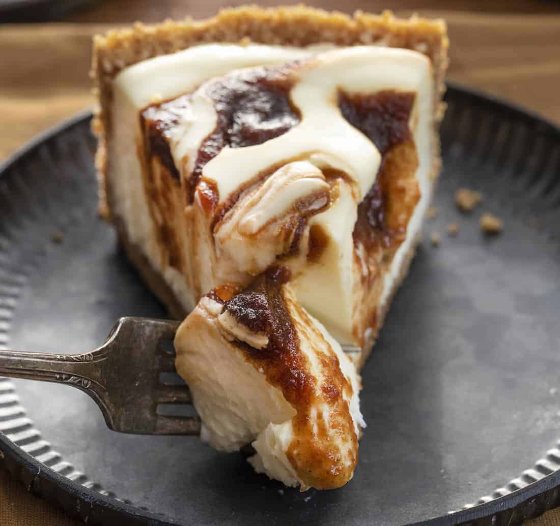 Apple Butter Cheesecake is a no-bake cheesecake made with a graham cracker crust filled with a creamy cheesecake and apple butter swirl. Cheesecake, Apple Butter Cheesecake, No Bake Cheesecake, Classic Cheesecake, Dessert, recipes, i am baker, iambaker Fork Taking a Bite of Apple Butter Cheesecake