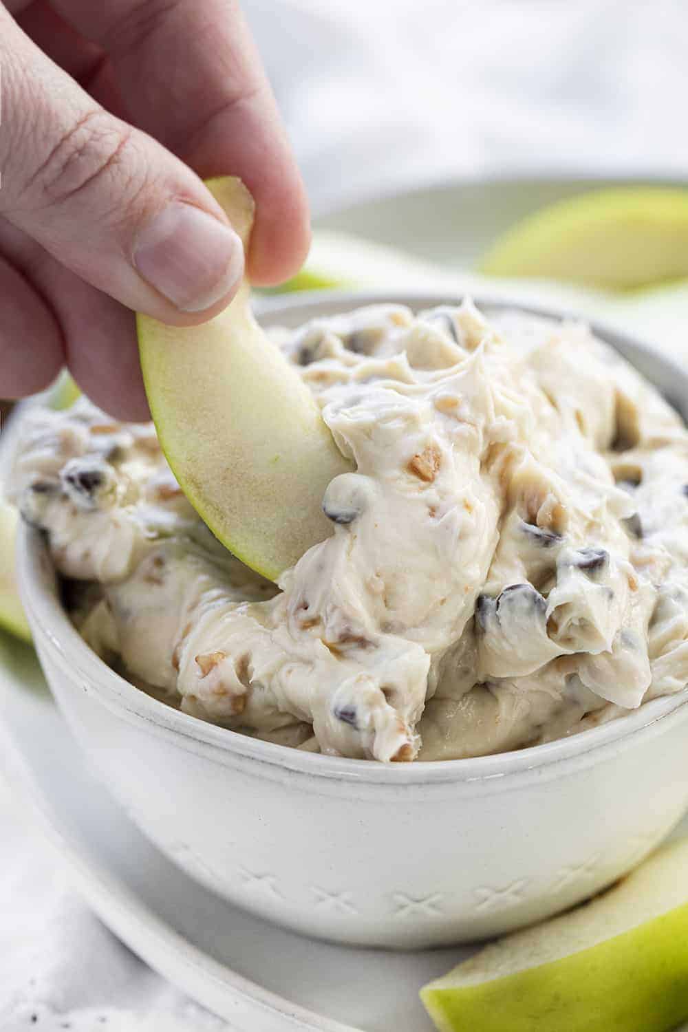 Apple Toffee Dip is a cream cheese-based, no-bake dip that is loaded with toffee bits and chocolate chips that is as easy to put together as it is delicious! Easy Dip, Apple Dip, Green Apple Dip, Col Dips, Appetizer, i am baker, iambaker, recipes Dipping Apple into Apple Toffee Dip