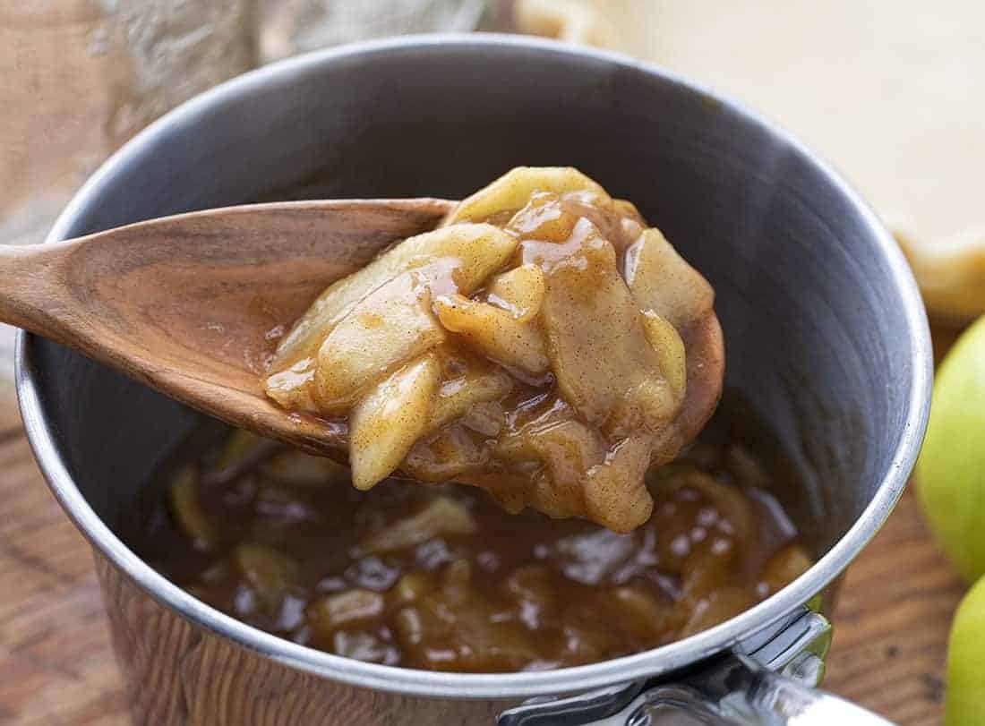 Apple Pie Filling is better than any pie filling you can buy at the store and is perfect for homemade apple pie, desserts, and even as a topping for ice cream! Apple Pie Filling, Pie Filling, How to Make Apple Pie Filling, Easy Apple Pie Filling, Pies, Baking, Cooking, Recipes, Apple Recipes, i am baker, iambaker Spoonful of Apple Pie Filling in Pan