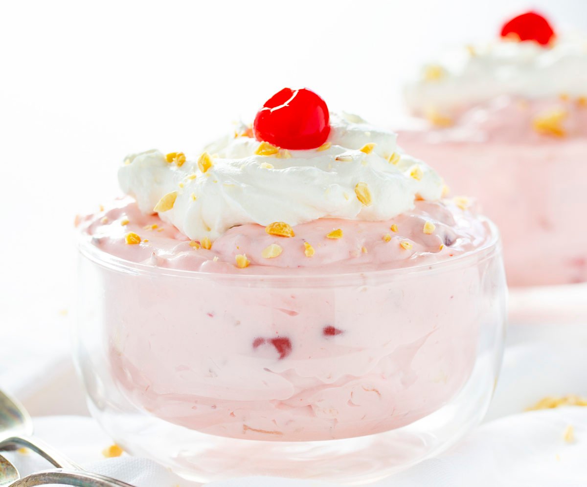 The best no-bake desserts to get your sweet tooth through the summer! no bake, no bake desserts, desserts, recipes, cheesecake, cookies, bars, cake, pudding, mousse, puppy chow, muddie buddies, rice krispy bars, dessert, memorial day dessert, labor day desserts, i am baker, iambaker Banana Split Fluff Easy in Glass Bowl with Cherry on Top.