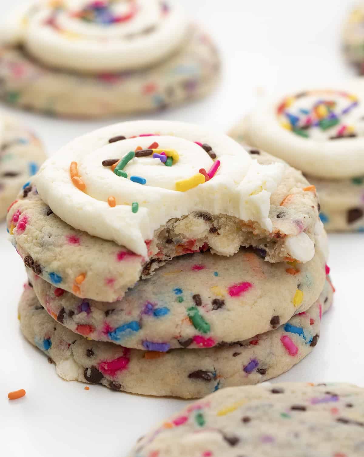 Birthday Cookies are chilled, but soft cookies that are loaded with colorful sprinkles, both chocolate and white chocolate chips, and topped with buttercream frosting. Cookies, Baking, Dessert, Birthday Cookies, Cookies with Frosting, Crumbl copycat cookie, birthday cookie recipes, cookie recipes, i am baker, iambaker Birthday Cake Cookies stacked with bite taken out