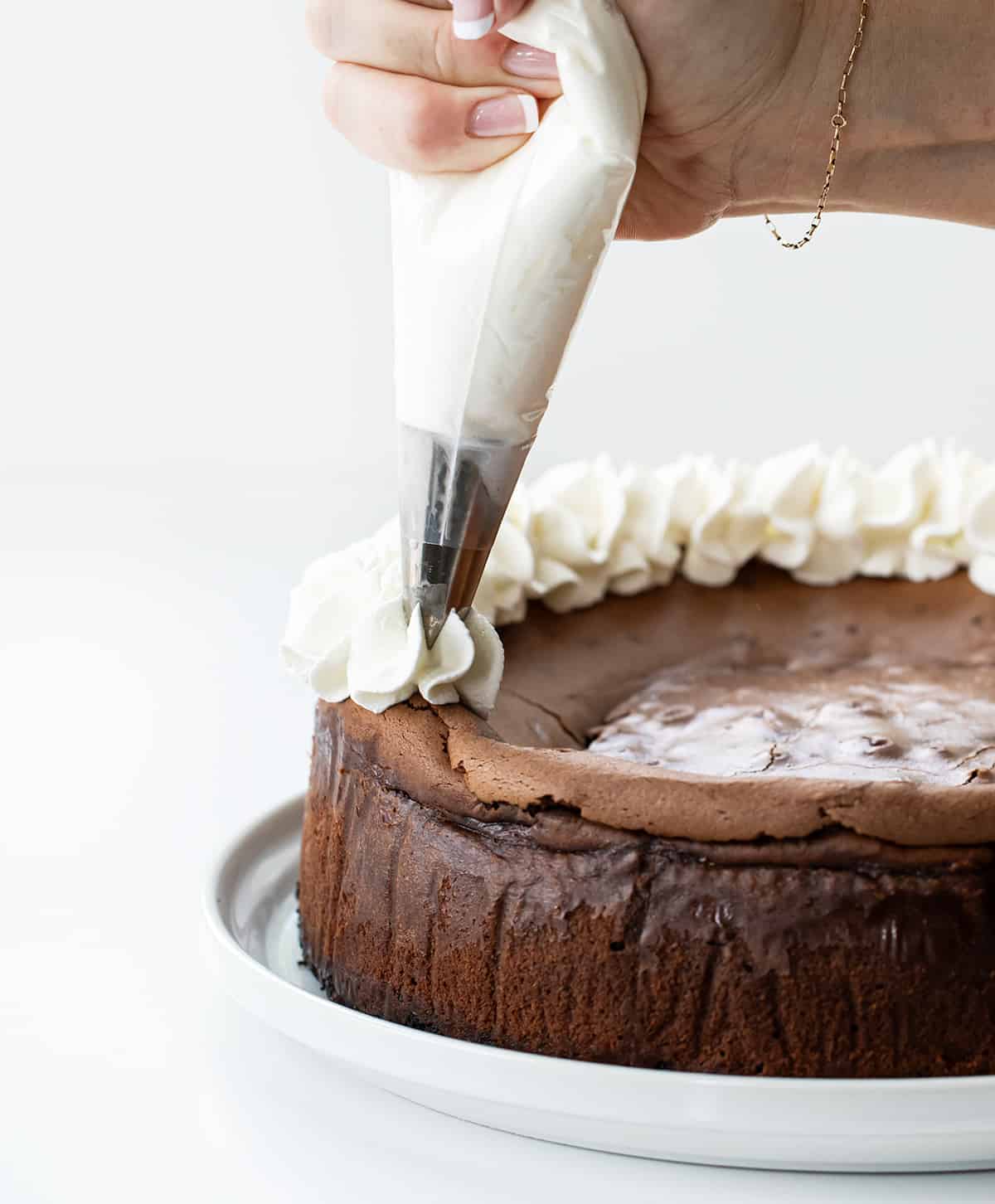 Black Forest Cheesecake is a rich chocolate cheesecake on top of an Oreo cookie crust, then topped with homemade cherry pie filling, chocolate curls, and whipped cream. It's a decadent dessert that brings together the delicious pairing of chocolate and cherries.