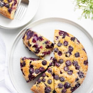 Whole Blueberry Breakfast Cake With Some Pieces Cut and One Piece Removed.