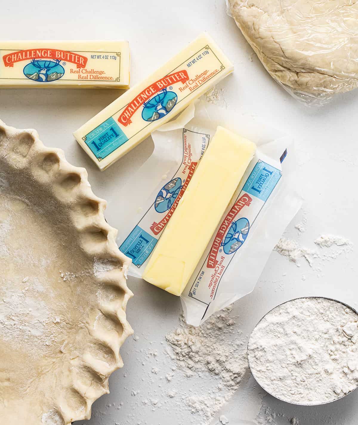Butter is a versatile ingredient that can be used in many ways, including spreading on bread, baking, and cooking. As a baker, I appreciate the flavor and texture that butter can add to recipes. However, many people have questions about the differences between unsalted and salted butter. I am here to answer those questions! Sticks of Butter Next to Pie Crust.