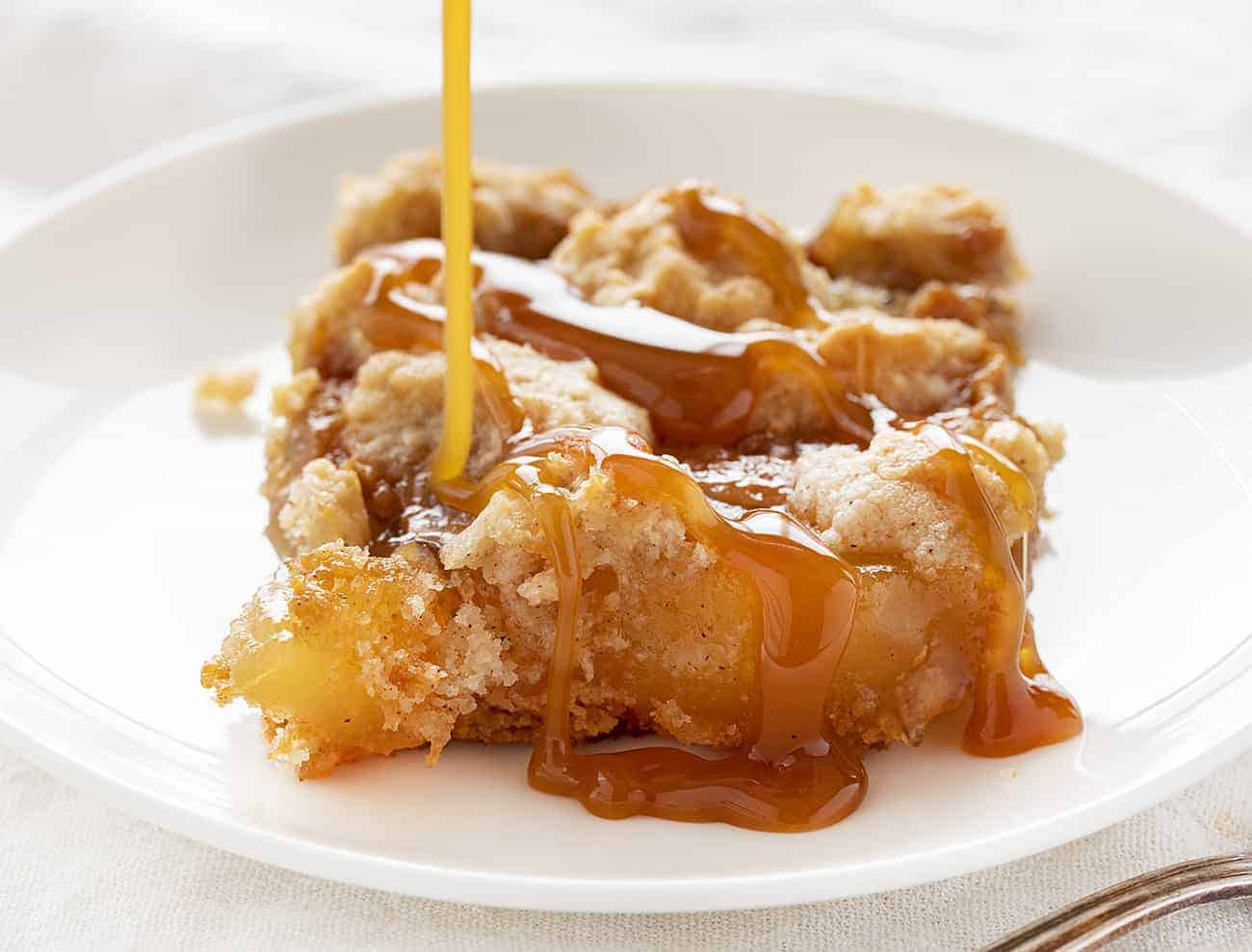 Satisfy everyone's sweet tooth with this Caramel Apple Dump cake--easy to make and to eat, for sure! caramelappledumpcake, caramelapple, desserts, iambaker, dumpcake, baking, thanksgivingdesserts, falldesserts Drizzling Caramel over Caramel Apple Dump Cake