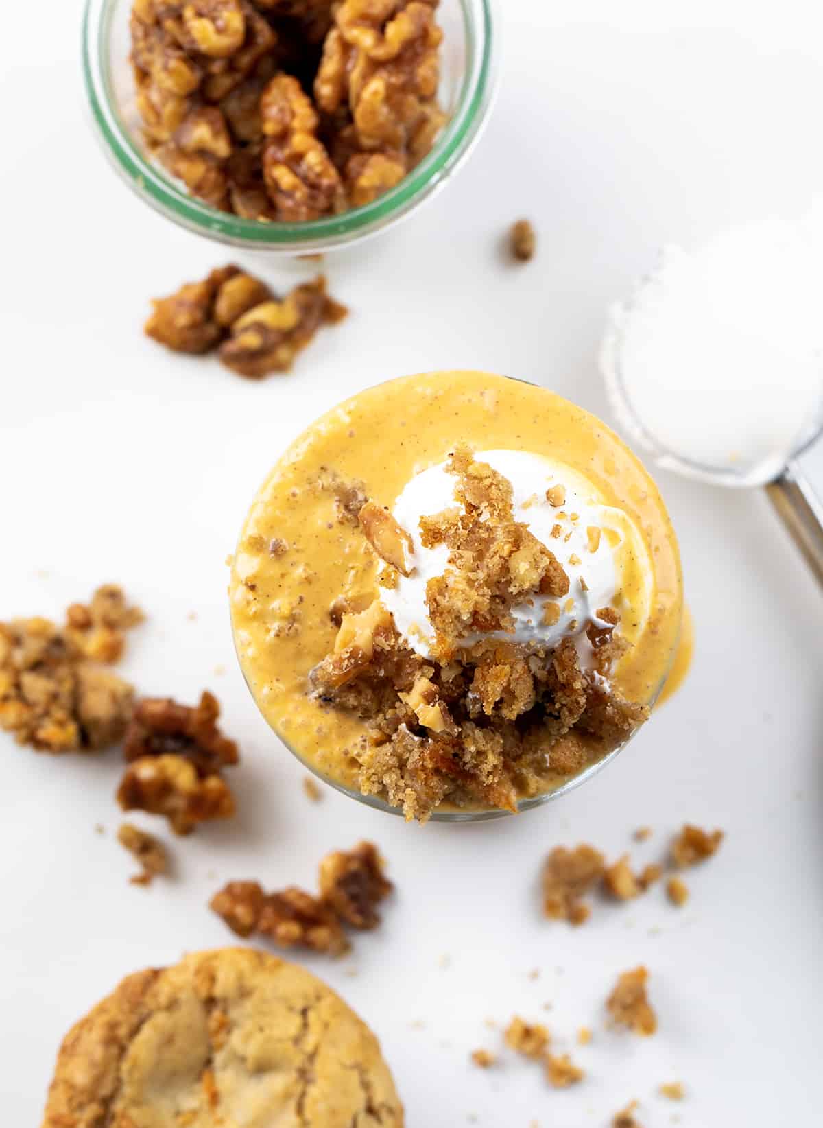 Carrot Cake Milkshake is a delightful and indulgent treat made with classic carrot cake flavors you can taste in each sip! In fact, I even used pieces of carrot cake in the shake. It will surely satisfy your sweet tooth and can be made in just a few minutes. But, there is a SURPRISE INGREDIENT that just might shock you!! Glass of Carrot Cake Milkshake with Whipped Cream and Crumbled Carrot Cake on Top. from Overhead Looking Down Into Glass.