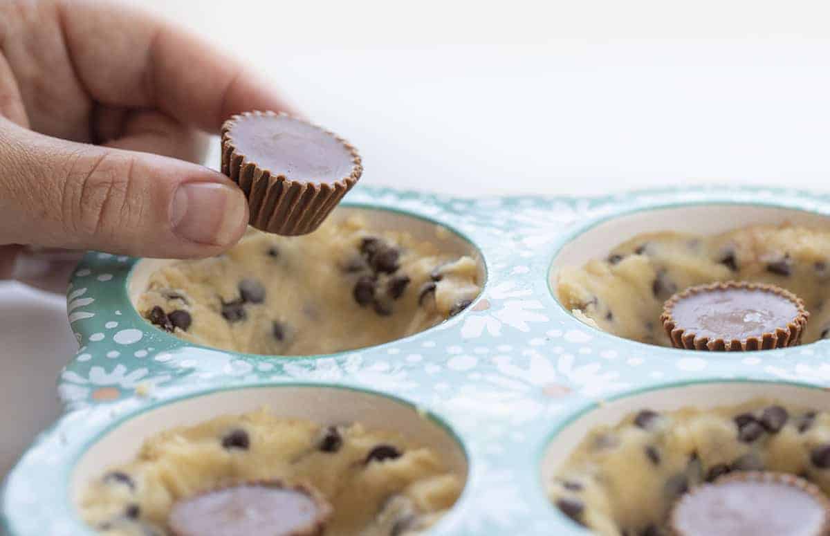 Chocolate Chip Cookie Cups is chocolate chip cookie dough baked in a muffin tin with a surprise mini Reese's Peanut Butter Cup nestled inside! Chocolate Chip Cookie Cups, Mini Chocolate Chip Cookie Cups, Cookie Cups, Cookies in Muffin Pan, Mini Chocolate Chip Cookie Recipe, Chocolate Chip Cookies Stuffed with Reese's, Reese's Chocolate Chip Cookies, Baking, Cookies, Cookie Recipes, CookieCups, i am baker, iambaker Adding Reese's Cup to Cookie Dough to Make Chocolate Chip Cookie Cups with Reese's Peanut Butter Cups