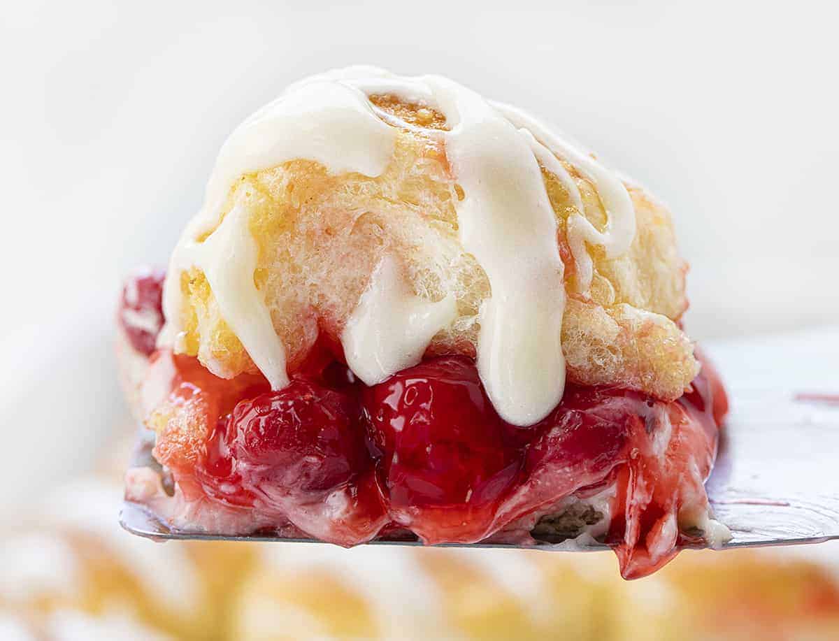 Cherry Cheesecake Sliders are a sweet, simple dessert that has all the flavors of cherry cheesecake tucked in between Hawaiian rolls and drizzled with a cream cheese frosting! Dessert Sliders, Dessert, Easy Desserts, Holiday Desserts, Memorial Day Dessert, July 4th Dessert, Sliders, Cherry Cheesecake Sliders, Cherry Cheesecake Desserts, i am baker, iambaker, baking, recipes One Cherry Cheesecake Slider on a Spatula Fresh From Baking
