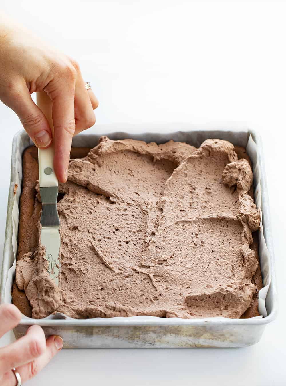 Chocolate Cheesecake Bars are creamy and chocolatey dessert bars with an Oreo cookie crust and homemade chocolate whipped topping. Chocolate Cheesecake, Cheesecake Bars, Chocolate Cheesecake Bars, Chocolate Bars, Triple Chocolate Bars, Dessert, Chocolate Dessert, Baking, i am baker, iambaker, recipes Spreading Chocolate Whipped Topping over Chocolate Cheesecake Bars