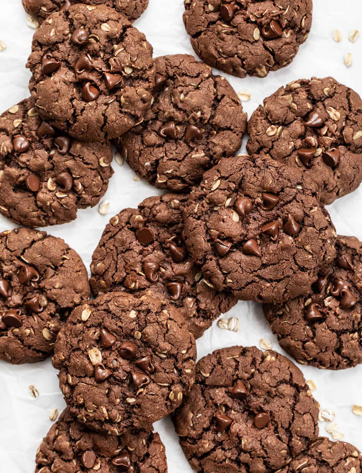 Chocolate Oatmeal Cookies are a delicious treat that has the perfect balance of chocolate and oats, creating a delightful texture and flavor combination. It is an oatmeal cookie with the earthy seasonings removed and then real chocolate added to the dough. The soft cookies can be enjoyed as an afternoon snack with a cup of coffee or tea or as a sweet dessert! Overhead of Chocolate Oatmeal Cookies on a White Counter.