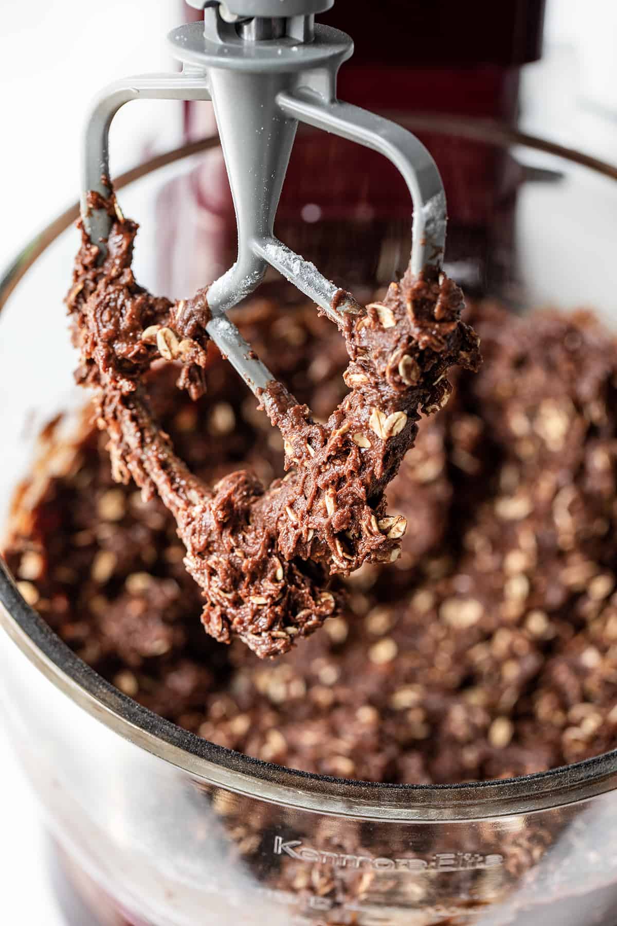 Chocolate Oatmeal Cookies are a delicious treat that has the perfect balance of chocolate and oats, creating a delightful texture and flavor combination. It is an oatmeal cookie with the earthy seasonings removed and then real chocolate added to the dough. The soft cookies can be enjoyed as an afternoon snack with a cup of coffee or tea or as a sweet dessert! Chocolate Oatmeal Cookie Dough on a Mixer Paddle.