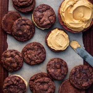 Cookies on a Dark Cutting Board with Peanut Butter Frosting and Adding Peanut Butter Frosting to Some Cookies.