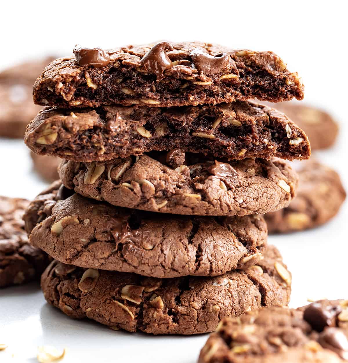 Chocolate Oatmeal Cookies are a delicious treat that has the perfect balance of chocolate and oats, creating a delightful texture and flavor combination. It is an oatmeal cookie with the earthy seasonings removed and then real chocolate added to the dough. The soft cookies can be enjoyed as an afternoon snack with a cup of coffee or tea or as a sweet dessert! Stack of Chocolate Oatmeal Cookies with Top Cookie Broken in Half.