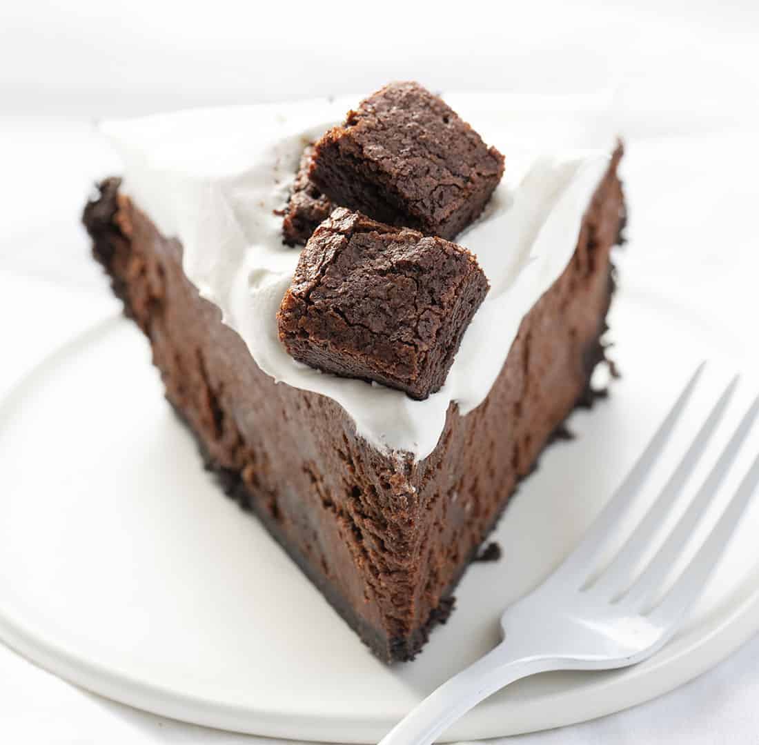 Death By Chocolate Pie is a chocolate lover's dream with its Oreo cookie crust and a creamy chocolate filling loaded with homemade brownie pieces and chocolate whipped cream. Death By Chocolate Pie - Chocolate Brownie Pie, Chocolate Pie, Brownie Pie, Chocolate, Pie, Baking, Brownie Pie, i am baker, Christmas, New Years, i am baker, recipes Death By Chocolate Pie - Chocolate Brownie Pie on White Plate