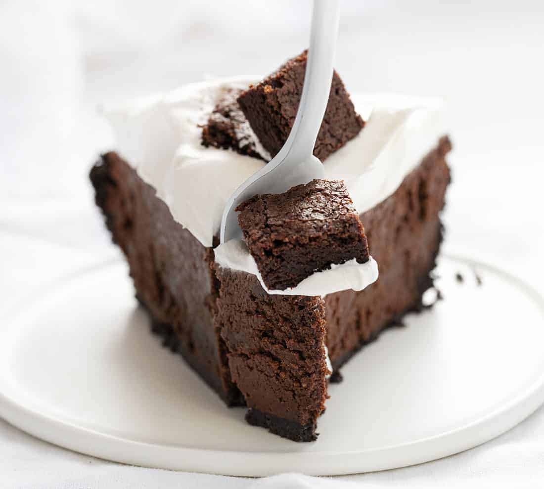 Death By Chocolate Pie is a chocolate lover's dream with its Oreo cookie crust and a creamy chocolate filling loaded with homemade brownie pieces and chocolate whipped cream. Death By Chocolate Pie - Chocolate Brownie Pie, Chocolate Pie, Brownie Pie, Chocolate, Pie, Baking, Brownie Pie, i am baker, Christmas, New Years, i am baker, recipes Fork Taking Bite of Death By Chocolate Pie - Chocolate Brownie Pie