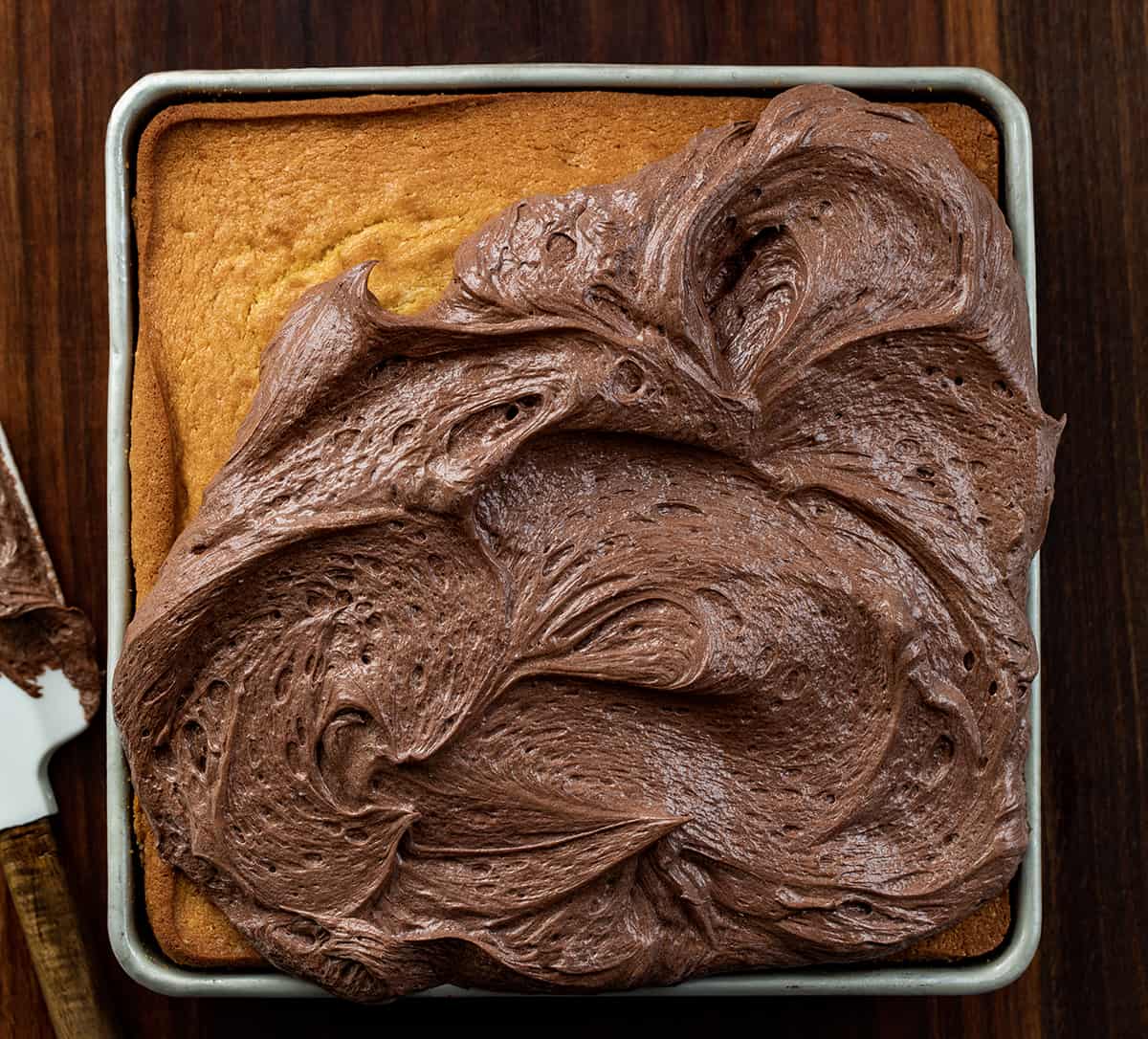 Chocolate Ermine Frosting is a silky smooth chocolate frosting made by cooking a milk and flour mixture and mixing it with butter, sugar, and cocoa powder. It is based on Ermine Frosting, or $300 Dollar Frosting, but with added cocoa powder for the chocolate flavor. Don't worry, this frosting will not cost you $300, but it is a delicious and versatile frosting for cakes and cupcakes, as a filling, and even as a dip! Partially frosted yellow cake using Chocolate Ermine Frosting.