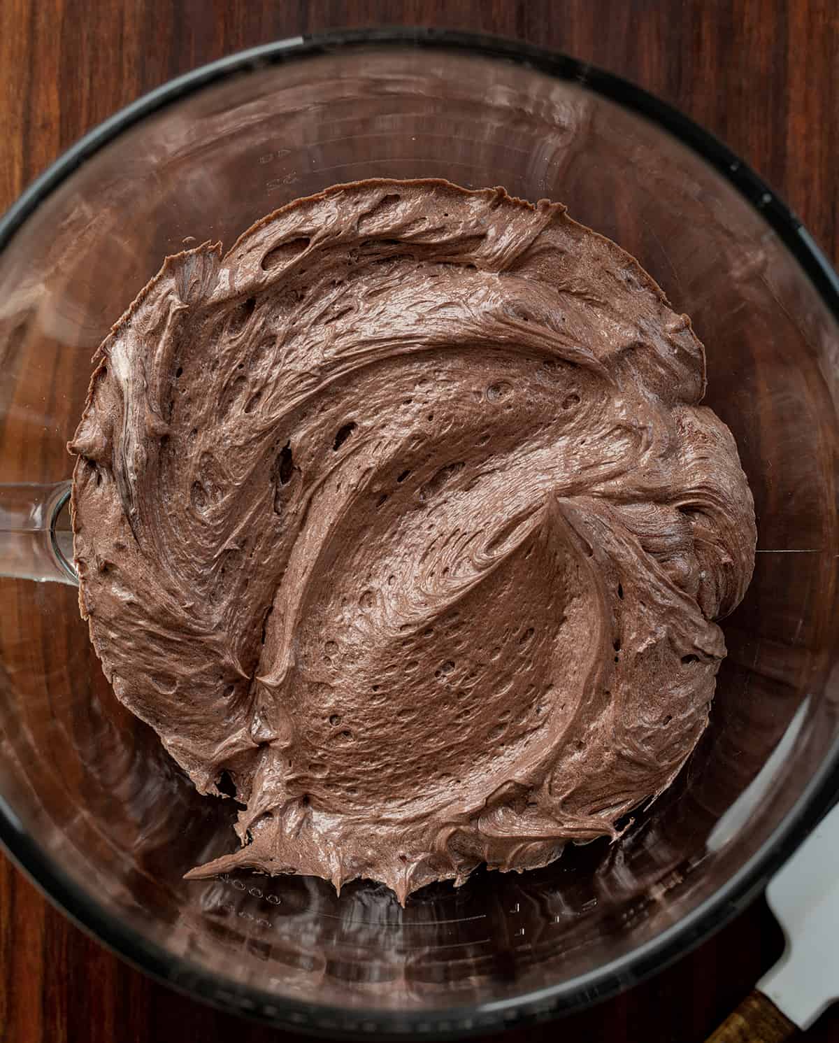 Chocolate Ermine Frosting is a silky smooth chocolate frosting made by cooking a milk and flour mixture and mixing it with butter, sugar, and cocoa powder. It is based on Ermine Frosting, or $300 Dollar Frosting, but with added cocoa powder for the chocolate flavor. Don't worry, this frosting will not cost you $300, but it is a delicious and versatile frosting for cakes and cupcakes, as a filling, and even as a dip! Chocolate Ermine Frosting in Bowl of Stand Mixer.
