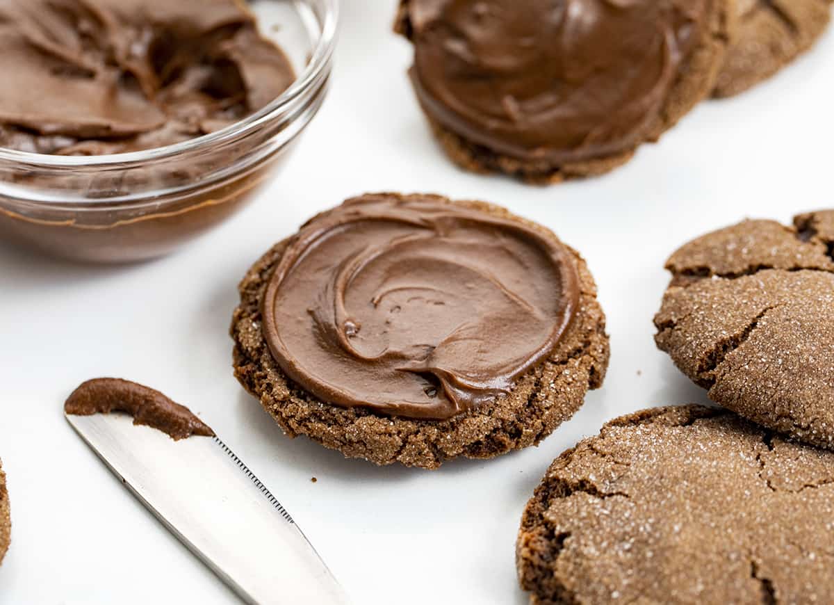 Chocolate Sandwich Cookies are soft, chewy, sugary chocolate cookies with a layer of decadent chocolate frosting in between. It's a chocolate lovers dream! Spreading Chocolate Frosting on a Chocolate Cookie.