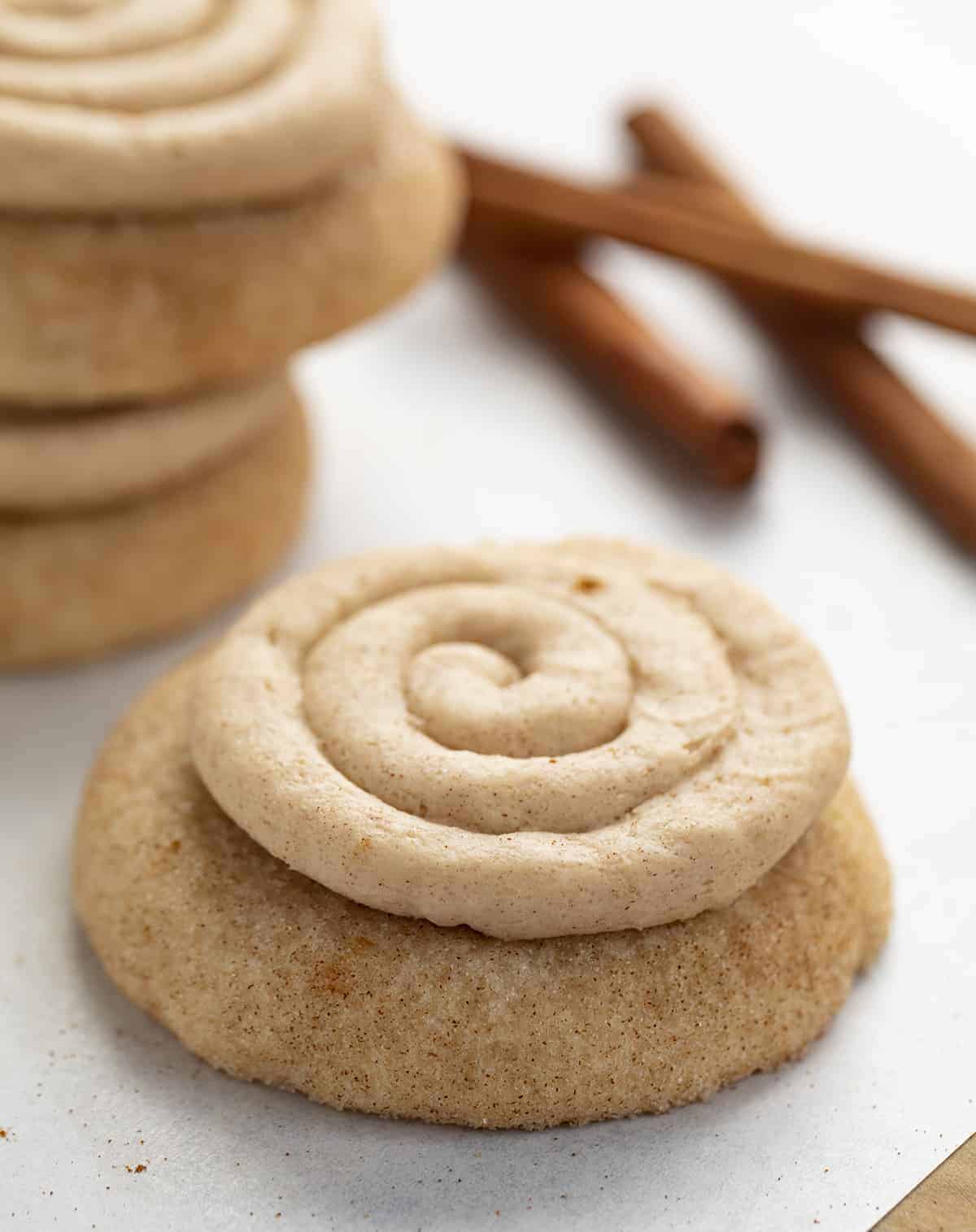 Churro Cookies are a Crumbl cookie copycat that are soft and chewy cinnamon sugar cookies topped with cinnamon buttercream. Copycat Cookies, Churro Cookies, Crumbl Cookie, Cinnamon Cookies, baking, Dessert, Fall Baking, Thanksgiving Cookie, Thanksgiving Dessert Recipes, New Years Dessert Cookies, Soft Cookies, i am baker, iambaker Churro Cookie on Parchment with Piped Buttercream