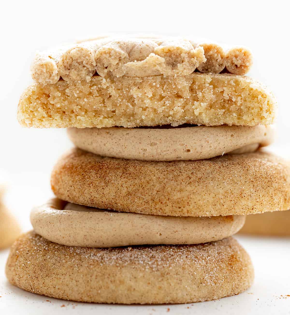 Churro Cookies are a Crumbl cookie copycat that are soft and chewy cinnamon sugar cookies topped with cinnamon buttercream. Copycat Cookies, Churro Cookies, Crumbl Cookie, Cinnamon Cookies, baking, Dessert, Fall Baking, Thanksgiving Cookie, Thanksgiving Dessert Recipes, New Years Dessert Cookies, Soft Cookies, i am baker, iambaker Stacked Churro Cookies with One Broken on Top