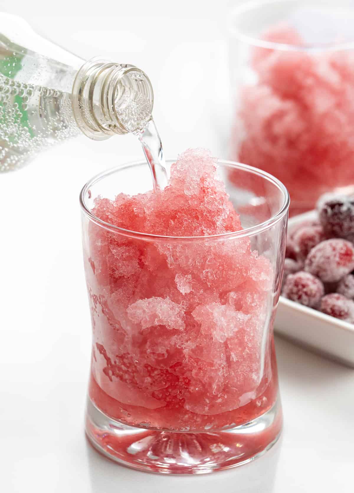 This Cranberry Slush is an adult beverage that is a holiday drink, but would also be delicious in the summertime, so don't forget about it. It's a festive and refreshing drink to serve with a lovely red color from the cranberries. Plus, the lemon-lime soda gives it some carbonation for a few bubbles. Serve it in a large punch bowl and let your guests help themselves! Cheers! Adding Sprite to Glass of Cranberry Slush