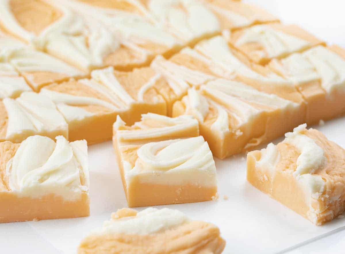 Orange Creamsicle Fudge is a sweet fudge made with just the right amount of orange flavor and white chocolate chips for a soft and smooth treat. Creamsicle, Orange Creamsicle, Creamsicle Fudge, Creamy Fudge, Fudge Recipe, How to Make Fudge, Dessert, recipes, BBQ, cookout dessert, July 4th dessert, i am baker, iambaker Cut Orange Creamsicle Fudge