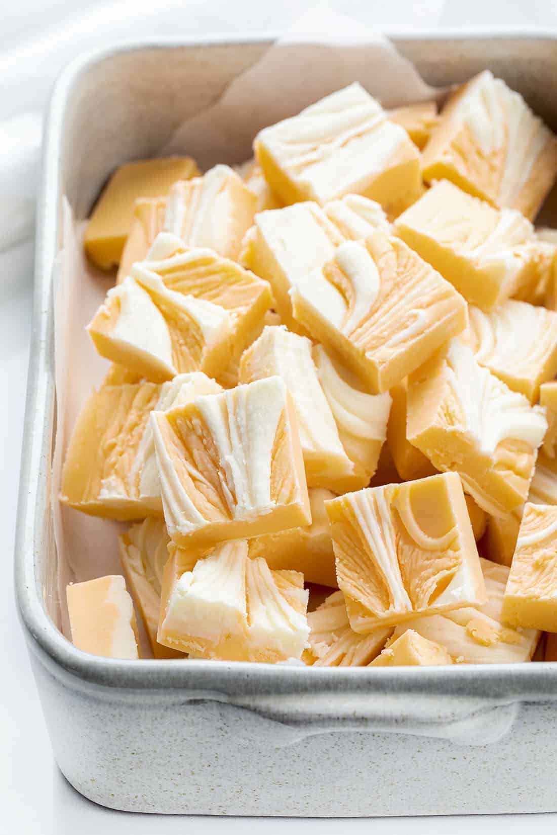 Orange Creamsicle Fudge is a sweet fudge made with just the right amount of orange flavor and white chocolate chips for a soft and smooth treat. Creamsicle, Orange Creamsicle, Creamsicle Fudge, Creamy Fudge, Fudge Recipe, How to Make Fudge, Dessert, recipes, BBQ, cookout dessert, July 4th dessert, i am baker, iambaker Pan of Cut Up Orange Creamsicle Fudge