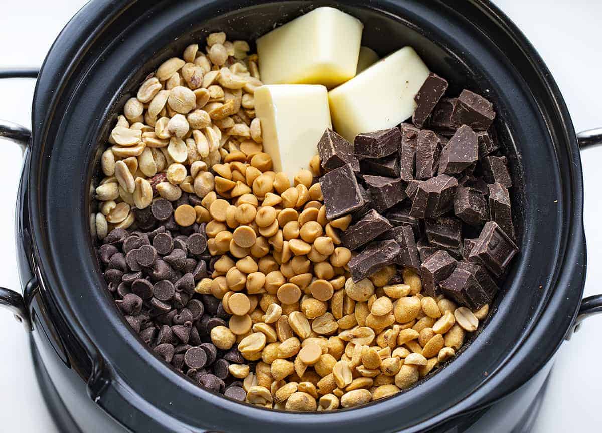 Crockpot Candy is made with two kinds of chocolate, almond bark, peanuts, and peanut butter chips, all melted and blended together in a slow cooker. Crockpot Candy, Chocolate in a Crockpot, Christmas Candy, Valentines Day Candy, Chocolate gifts, chocolate recipes, i am baker, iambaker, candy Overhead of Chocolate in Crockpot