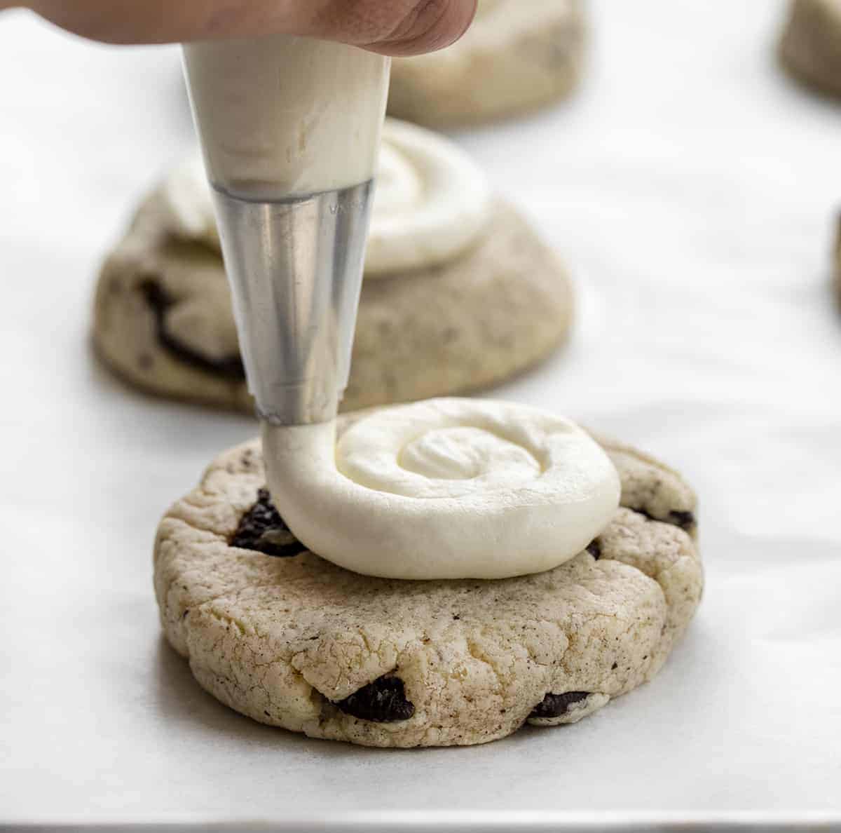 Copycat Crumbl Oreo Cookies are chilled, but super soft cookies that are filled with crushed Oreos and topped with homemade buttercream frosting. Cookies, Baking, Crumbl Cookie Recipe, Copycat Cookies, Frosted Cookies, Oreo Cookies, Dessert, i am baker, iambaker, recipes Adding Frosting to Copycat Crumbl Cookies & Cream Cookie