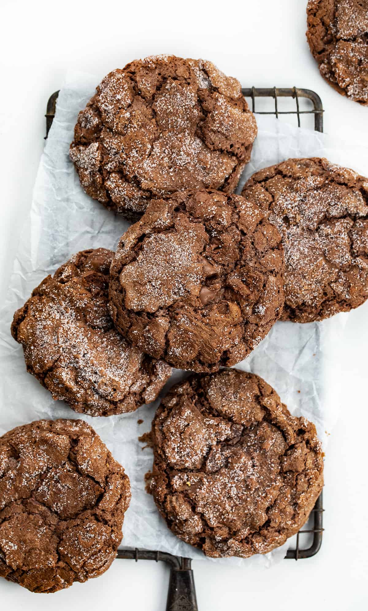 Dirty Chocolate Cookies are rich chocolate cookies rolled in sugar with a crispy outside and a soft, chewy center. Using two kinds of chocolate in the cookies makes them a decadent and indulgent treat with a deep chocolate flavor in every bite. They are worth the crumbs and sugar that may get everywhere! Dirty Chocolate Cookies Stacked on a Cooling Rack.