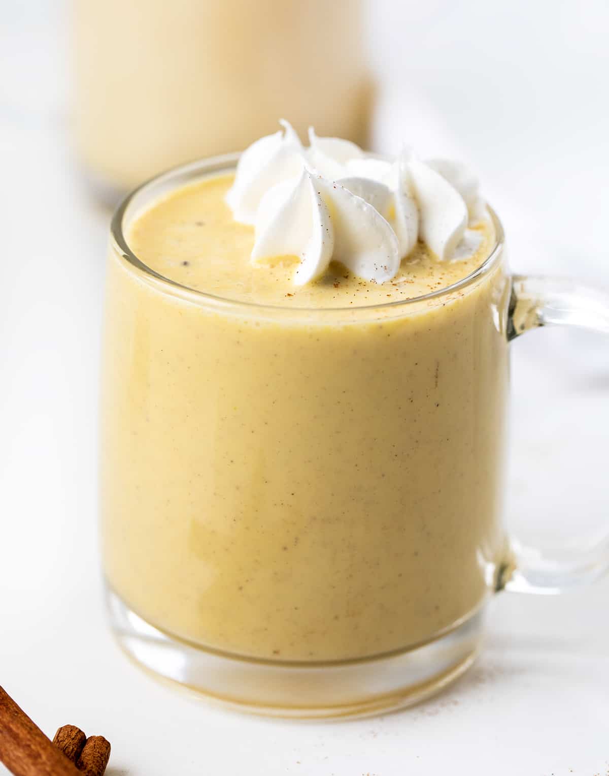 Eggnog is a creamy, egg-yolk-based holiday drink with just the right amount of spice that can be made with or without alcohol. It's delicious either way! And, when you make your own batch, you know exactly what is going into it without all the added preservatives. Better yet, you can adapt the recipe for all ages, making it a Christmas mocktail recipe if you leave out the alcohol. Glass mugs filled with eggnog and topped with whipped cream.