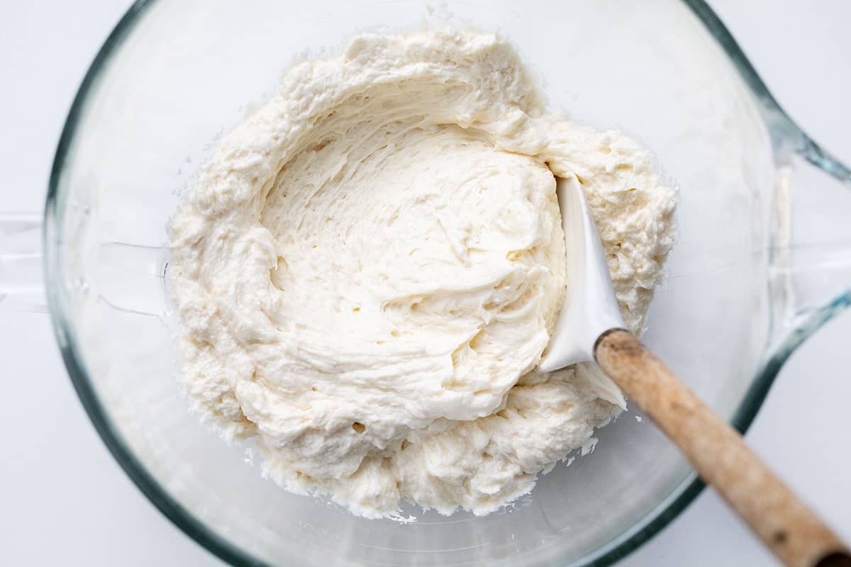 Ermine Frosting, also known as milk frosting, flour buttercream, flour frosting, or $300 Dollar Icing is a silky smooth frosting made from a cooked milk and flour mixture, sugar, and butter. It is made without eggs and is traditionally used to frost red velvet cake. But, don't stop there; its light and airy texture is perfect as a topping for a variety of cakes and cupcakes! Ermine Frosting in a Bowl.