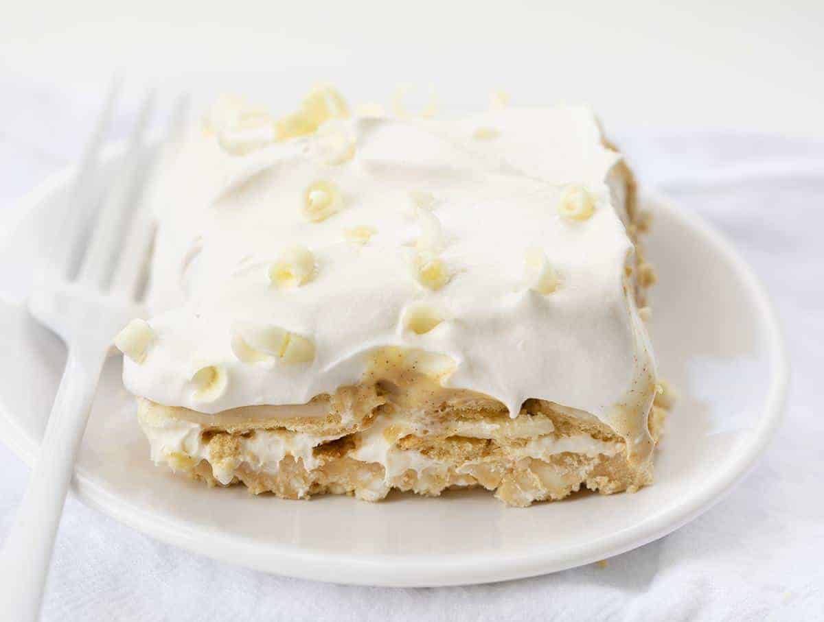 The best no-bake desserts to get your sweet tooth through the summer! no bake, no bake desserts, desserts, recipes, cheesecake, cookies, bars, cake, pudding, mousse, puppy chow, muddie buddies, rice krispy bars, dessert, memorial day dessert, labor day desserts, i am baker, iambaker Golden Oreo Dessert - You're Gonna Love It! on a white plate with white fork.
