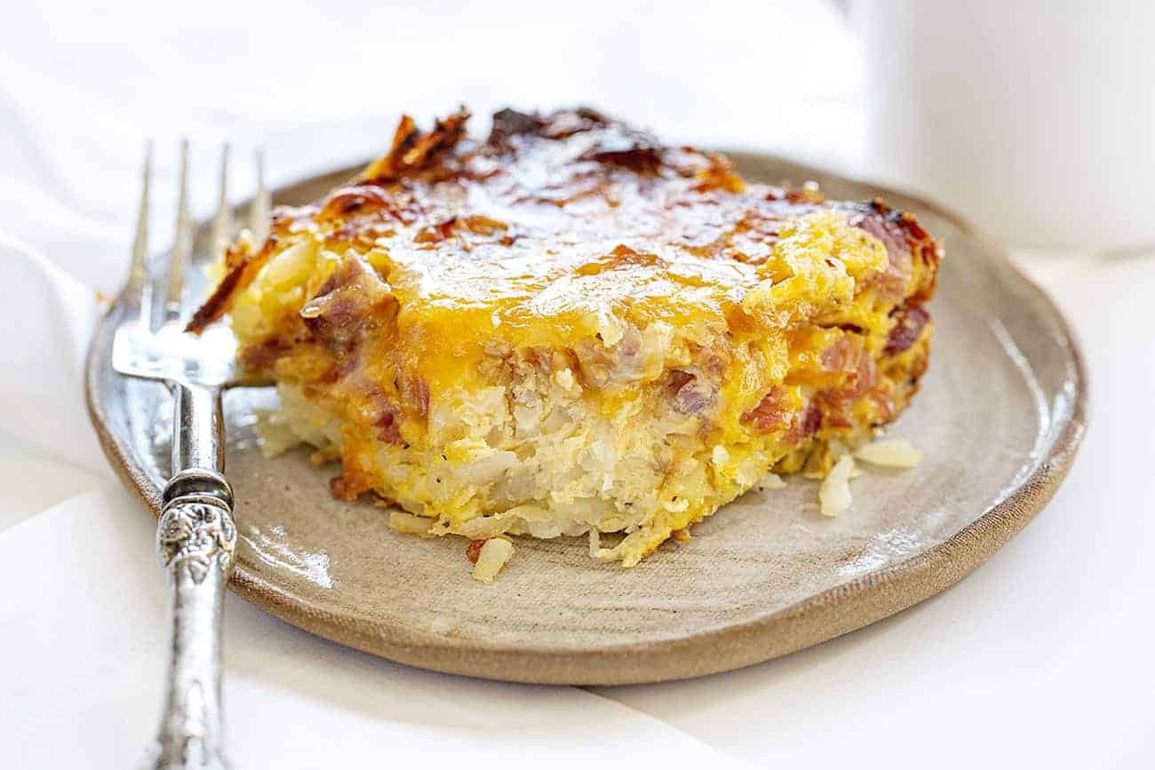 This ooey gooey cheesy ham and crisp hashbrown casserole is going to be a new favorite way to serve breakfast! casserole, ham casserole, cheesy casserole, breakfast casserole, breakfast, ham and cheese breakfast, iambaker Ham Breakfast Casserole