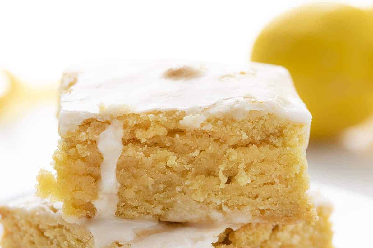 Lemon Brownies are dessert bars that are dense and moist with a lemony flavor and topped with a vanilla glaze. Lemon Brownies, Lemon Blondies, Fudgy Lemon Brownie, The Best Lemon Brownie, Baking, Lemon Recipes, Dessert, i am baker, iambaker Close up of Lemon Brownies