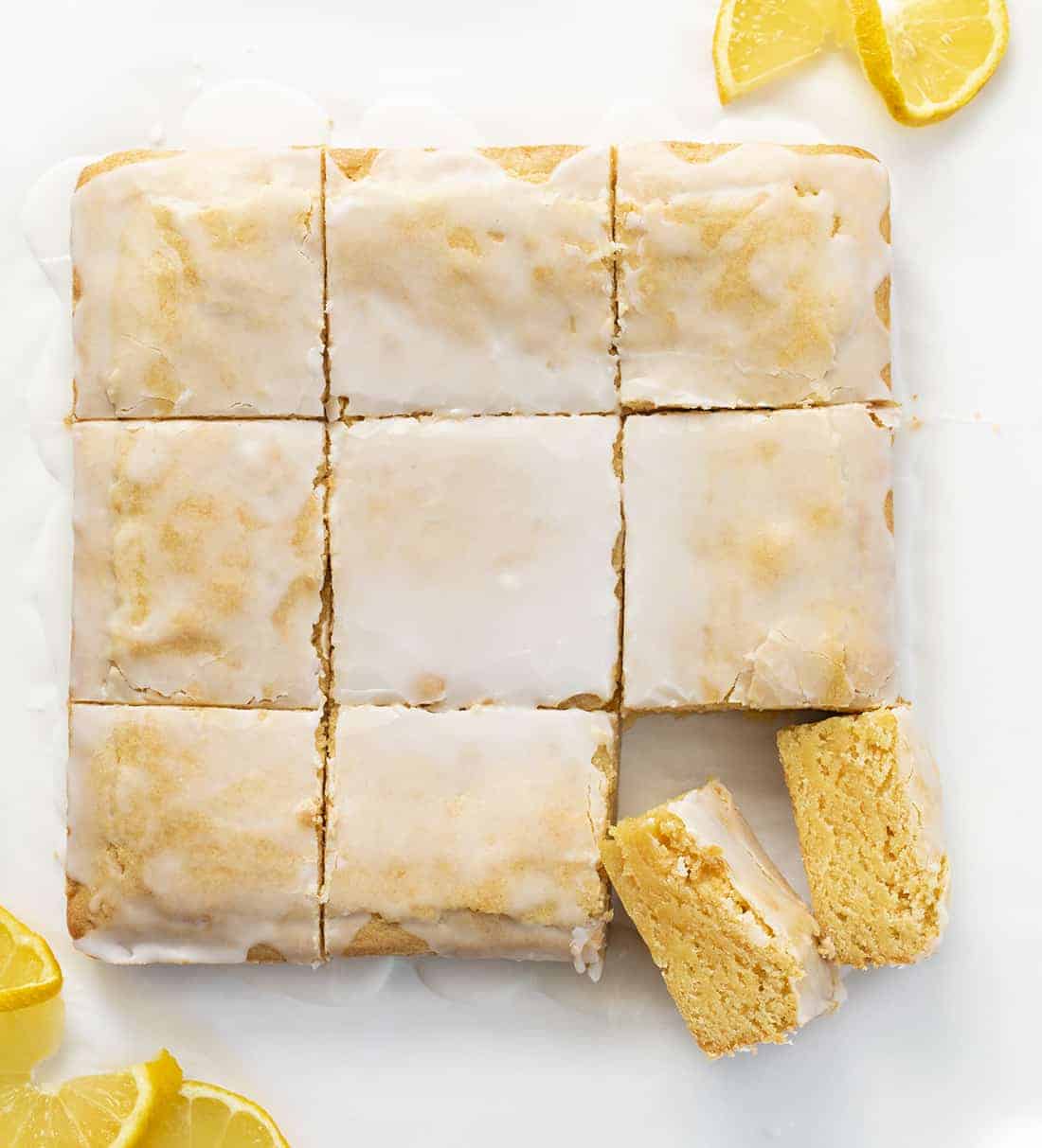Lemon Brownies are dessert bars that are dense and moist with a lemony flavor and topped with a vanilla glaze. Lemon Brownies, Lemon Blondies, Fudgy Lemon Brownie, The Best Lemon Brownie, Baking, Lemon Recipes, Dessert, i am baker, iambaker Lemon Brownies from Overhead with Vanilla Glaze