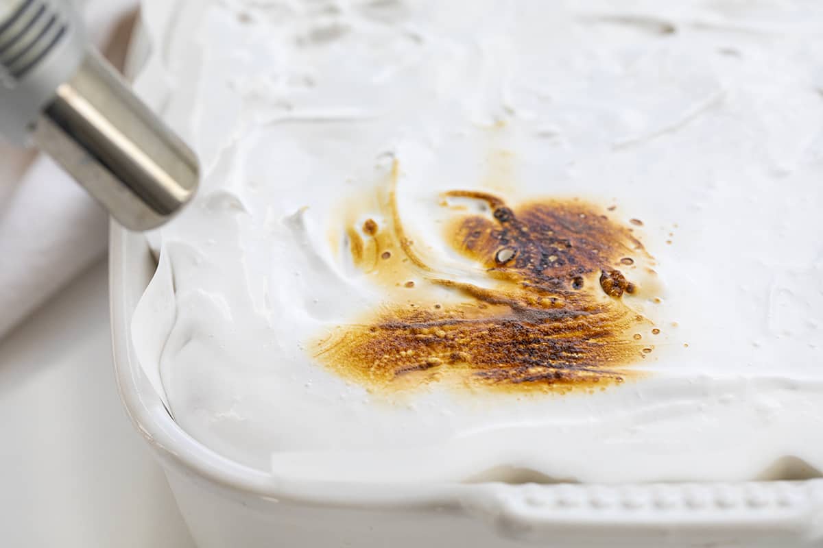 Toasted Marshmallow Brownies are a layer of baked brownies that are topped with homemade marshmallow that is toasted to a golden brown. Brownie Recipes, Homemade Marshmallow, How to Make Marshmallow, Toasted Marshmallow, Baking, Dessert, BBQ Dessert, cookout desserts, campfire, recipes, i am baker, iambaker Toasting the Marshmallows on Marshmallow Brownies