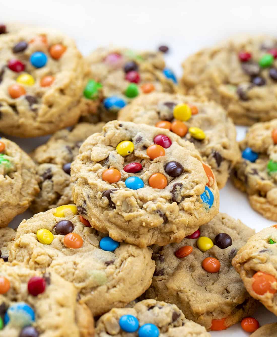 Soft Batch Monster Cookies are a cross between a soft peanut butter cookie and an oatmeal cookie that is loaded with peanut butter, oats, M&M's, and chocolate chips. Cookies, Baking, Monster Cookies, M&M Cookies, Cookie Recipes, i am baker, iambaker, dessert Stacked Soft Batch Monster Cookies