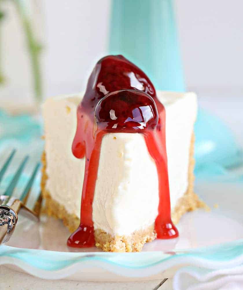 Are you are craving the silky smooth delightfulness that is Cheesecake but don't want to turn on your oven? I have found the perfect No-Bake Cheesecake recipe for you! #nobake #dessert #cheesecake #nobakecheesecake #recipes #cheesecake #iambaker Piece of Cheesecake with Strawberries on Top