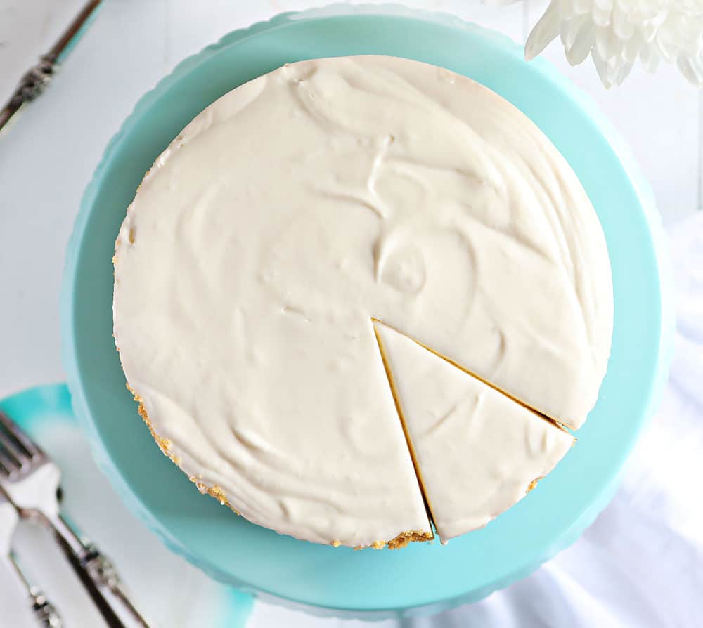 Are you are craving the silky smooth delightfulness that is Cheesecake but don't want to turn on your oven? I have found the perfect No-Bake Cheesecake recipe for you! #nobake #dessert #cheesecake #nobakecheesecake #recipes #cheesecake #iambaker Overhead of No Bake Cheesecake with Slice Cut