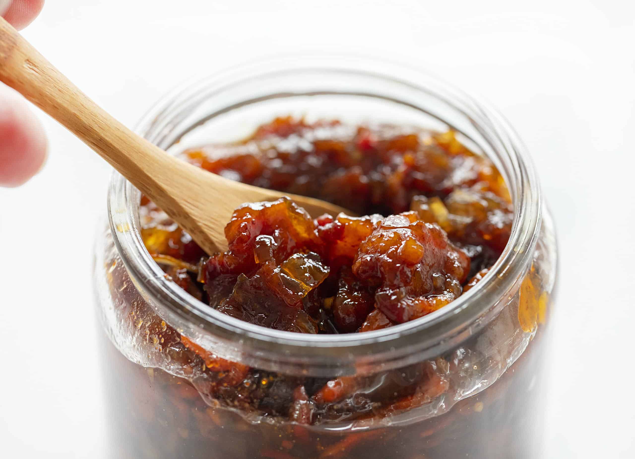 This Onion Bacon Jam recipe is literally the best in the world. I know that's a big statement, but I've been told that so many times that I have to believe it! Bacon Jam, Onion Bacon Jam, How to Make Bacon Jam, How to Make Onion Bacon Jam, Onion Bacon Jam Recipe, Bacon Jam Recipe, Appetizer, holiday appetizer, make ahead appetizer, easy appetizer, i am baker Onion Bacon Jam in a Jar with a Spoon