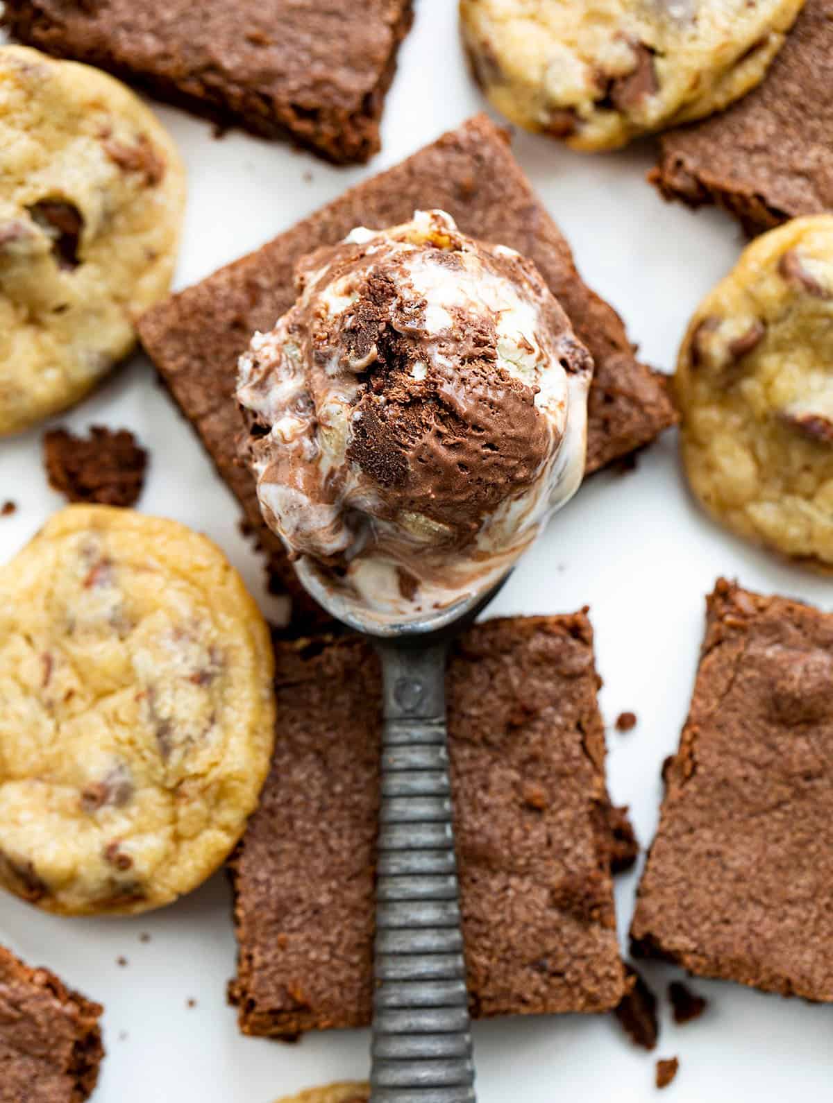 Scoop of Cookie Dough Brownie Ice Cream on Top of Brownies and Cookie Dough.