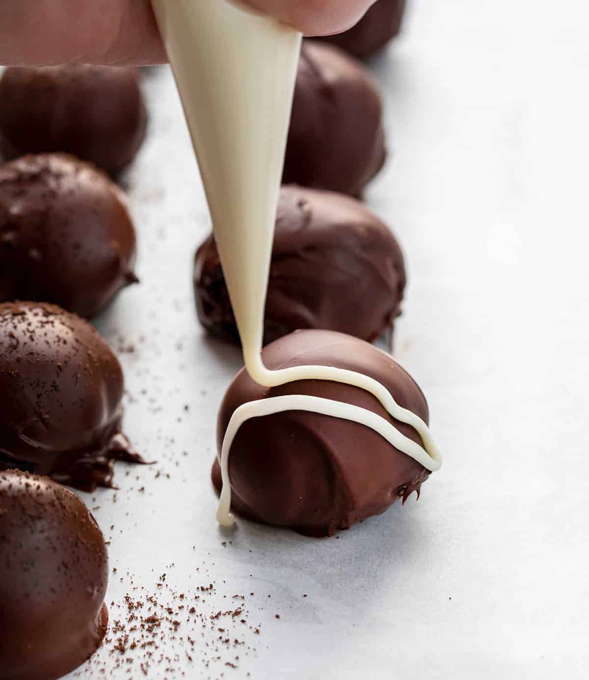 Oreo Truffles are a sweet treat made with crushed Oreo cookies and cream cheese, coated in melted semisweet chocolate. Dessert, Snack, Oreo Balls, Oreo Truffles, Oreo treats, oreo recipes, bbq, superbowl food, finger food, baking, no bake, no bake recipes, i am baker, iambaker Drizzling Oreo Balls with Melted Chocolate