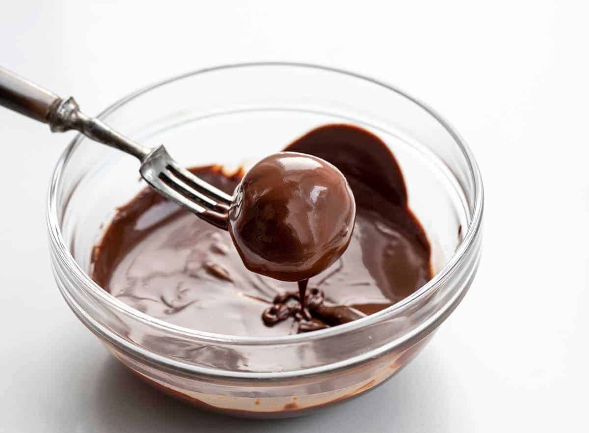 Oreo Truffles are a sweet treat made with crushed Oreo cookies and cream cheese, coated in melted semisweet chocolate. Dessert, Snack, Oreo Balls, Oreo Truffles, Oreo treats, oreo recipes, bbq, superbowl food, finger food, baking, no bake, no bake recipes, i am baker, iambaker Dipping Oreo Balls into Melted Chocolate