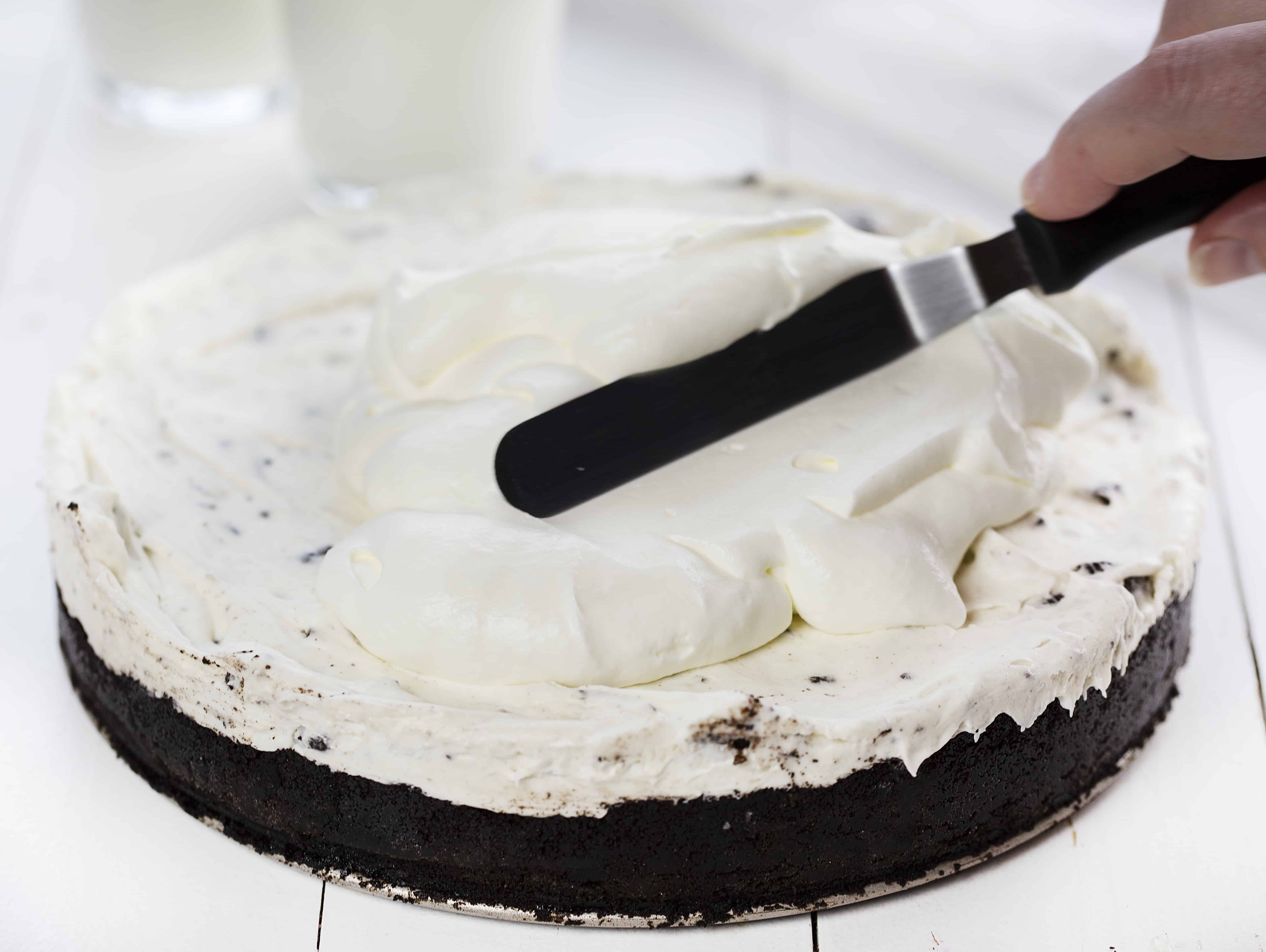 No Bake Oreo Cheesecake is so delicious no one will believe you didnt bake it! no bake, no bake desserts, cheesecake, no bake cheesecake, oreo, oreo cheesecake, no bake oreo cheesecake, iambaker No Bake Oreo Cheesecake with Homemade Whipped Topping Being Spread on Top