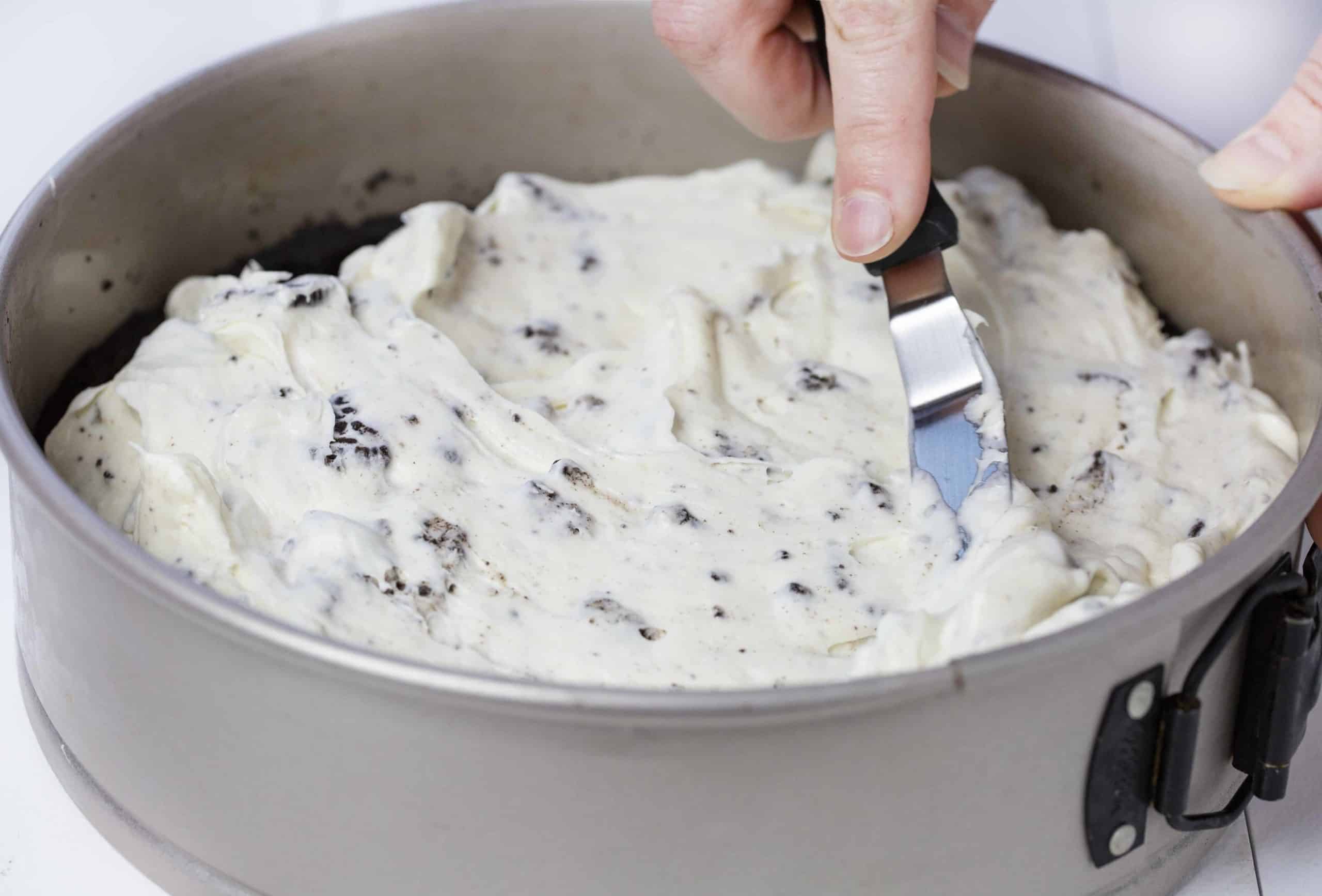 No Bake Oreo Cheesecake is so delicious no one will believe you didnt bake it! no bake, no bake desserts, cheesecake, no bake cheesecake, oreo, oreo cheesecake, no bake oreo cheesecake, iambaker Cream Cheese Mixture Being Spread on No Bake Oreo Cheesecake