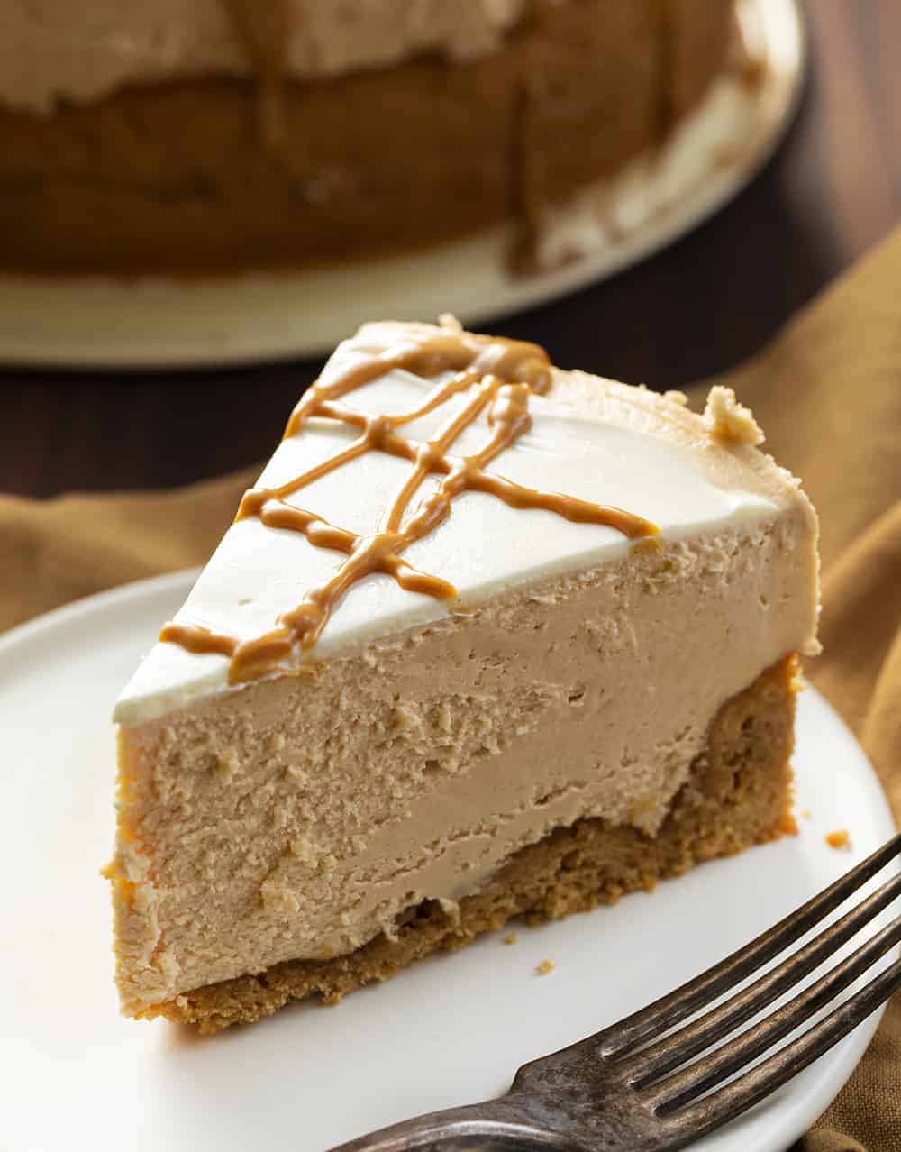 Peanut Butter Cheesecake is a smooth and creamy cheesecake made with peanut butter and a homemade peanut butter cookie crust. Peanut Butter Cheesecake, Decadent Cheesecake, Cheesecake Recipes, Peanut Butter Desserts, Dessert, Triple Peanut Butter Cheesecake, i am baker, iambaker, recipes, Christmas, New Years Eve Slice of Peanut Butter Cheesecake