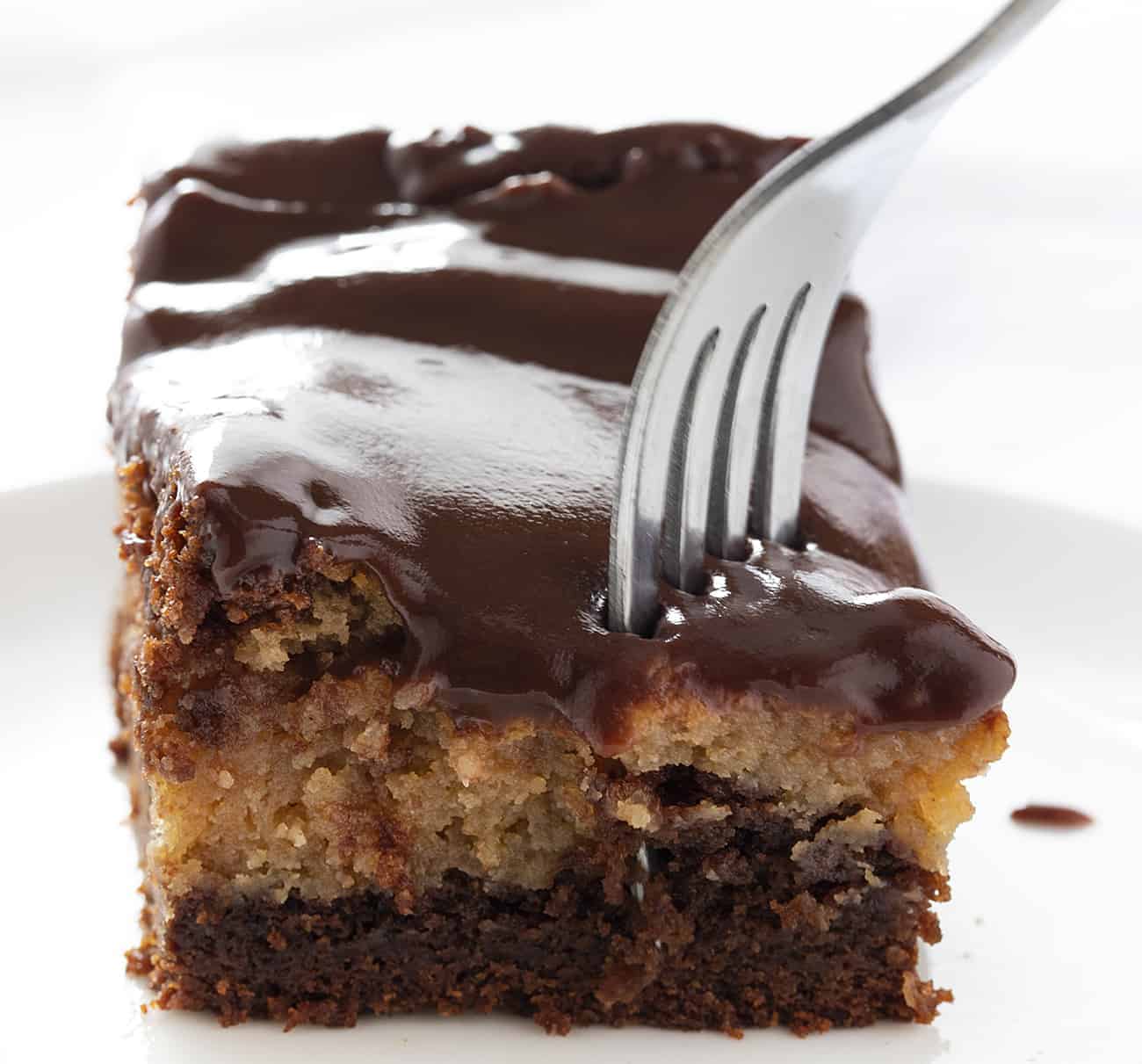 Chocolate Peanut Butter Ooey Gooey Cake takes my Chocolate Ooey Gooey Cake to a new level--a peanut butter level! chocolate peanut butter ooey gooey cake, chocolate ooey gooey cake, ooey gooey butter cake, chocolate peanut butter cake, chocolate cake, how to bake chocolate peanut butter ooey gooey cake, chocolate peanut butter ganache, ganache, dessert recipes, baking, i am baker Fork Taking Piece from Chocolate Peanut Butter Ooey Gooey Cake